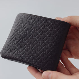 COSMIC WONDER monogram embossed light leather bifold wallet